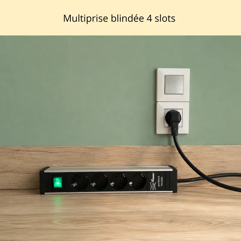 Multiprise blindée noire à 4 prises inclinées branché sur une prise de courant à la terre